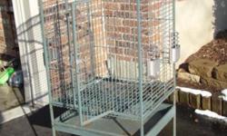 Parrot bird cage on rollers; 24 in. across (w/front door in center); 20 in. wide on sides; 56.5 in. tall from top to bottom; actual bird cage 34.5 in. tall (top to bottom). Two (2) feeding doors on one side and one (1) feeding door on other side; dome top